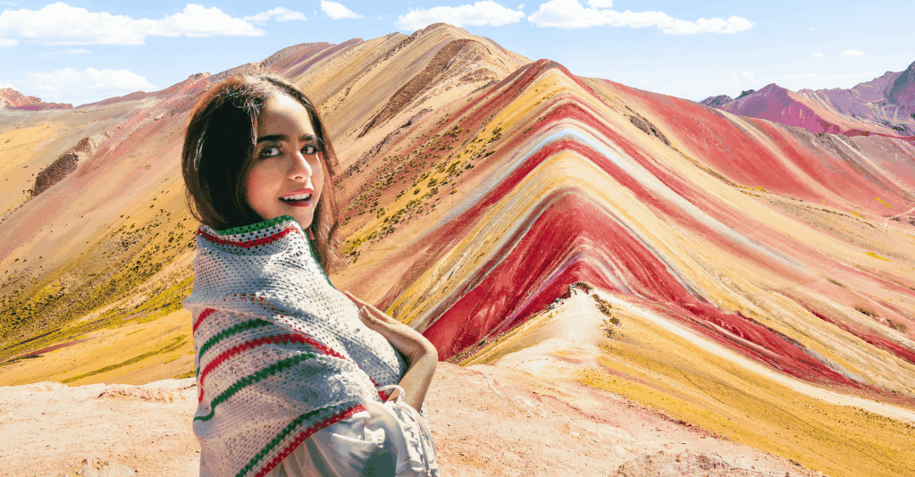 Vista panorámica de la Montaña de 7 Colores (Vinicunca) en Cusco con turistas caminando por la ruta.