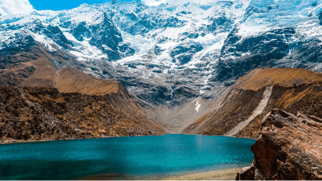 Vista panorámica de la Laguna Humantay con aguas turquesas y montañas nevadas al fondo.